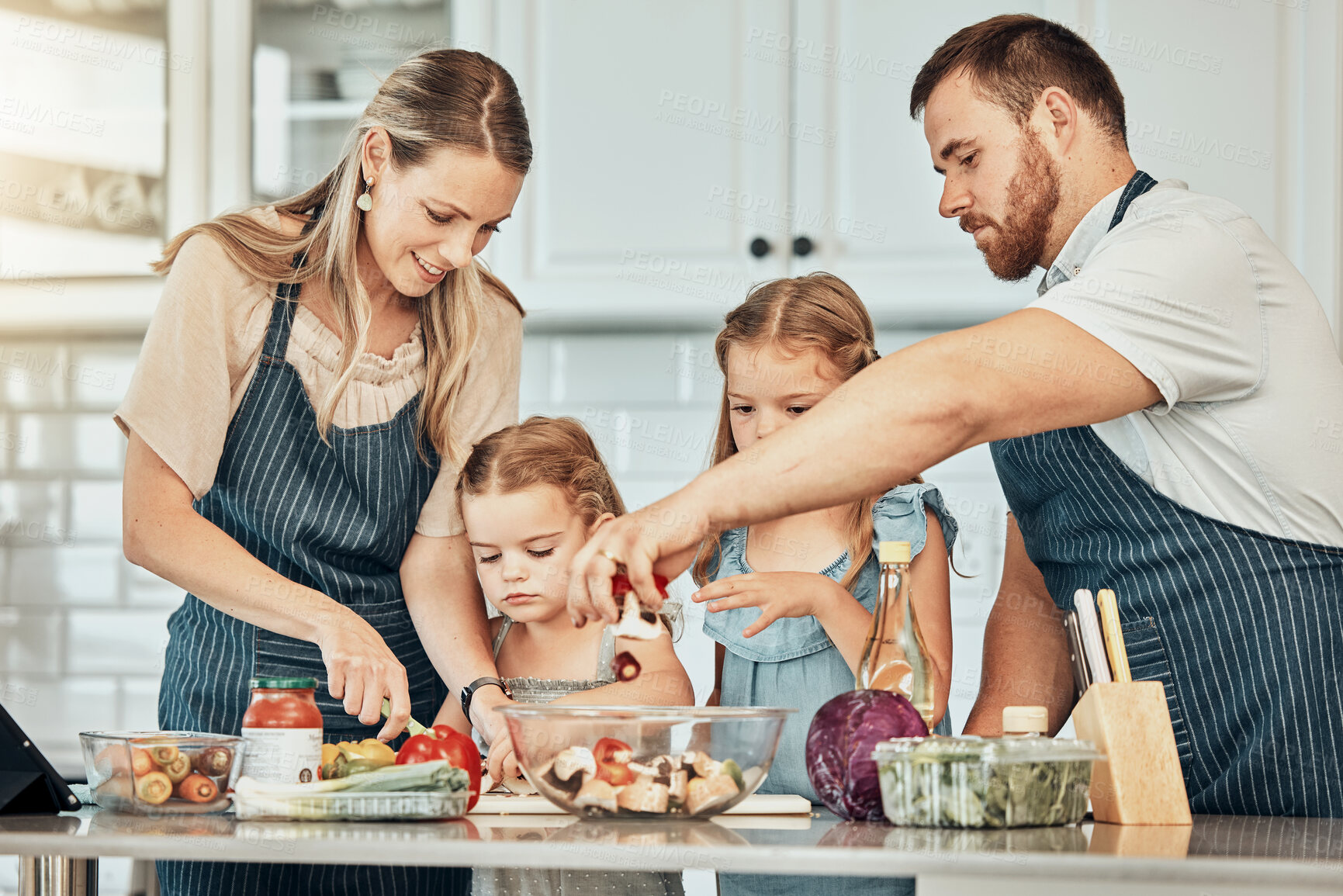 Buy stock photo Happy family in kitchen, cooking together with kids and teaching, learning and nutrition with parents. Mom, dad and girl children help making healthy food in home with care, support and love at lunch