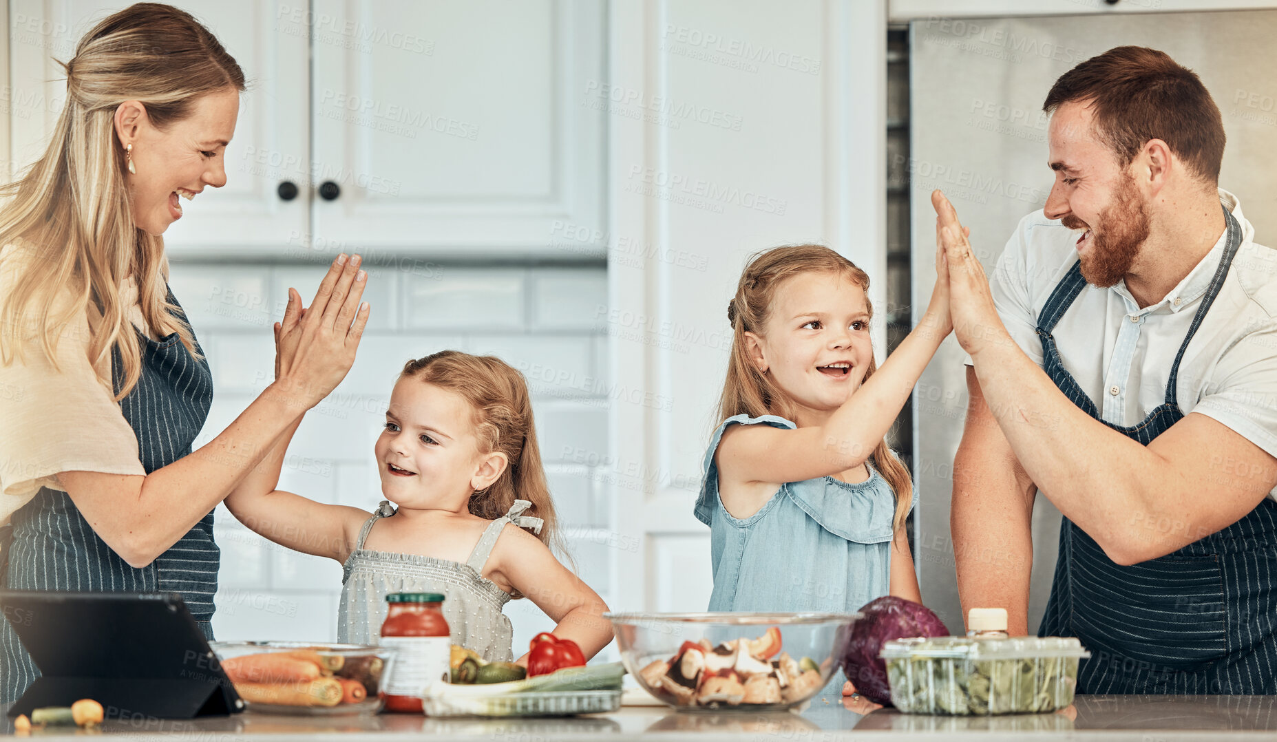 Buy stock photo Happy family in kitchen, cooking with kids and high five with success, learning and nutrition with parents. Mom, dad and girl children making healthy food in home with care, celebration and lunch.