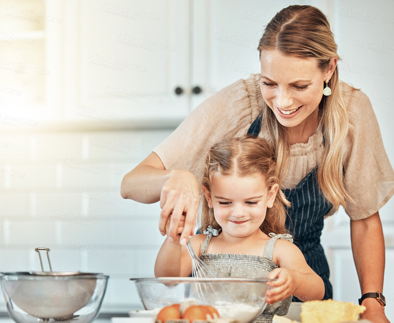 Buy stock photo Mom, girl child and teaching with whisk, development and skills with baking, love and care in family home. Cooking, mother and daughter with smile, flour and eggs on table, kitchen and help for food