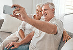 Happy, old couple and selfie on sofa in home, living room or apartment in retirement with post on social media. Mature, people and smile in profile picture, live stream or video call with smartphone