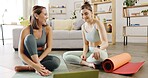 two young women using a laptop while working out at home, fitness and yoga at home discussing and online tutorial