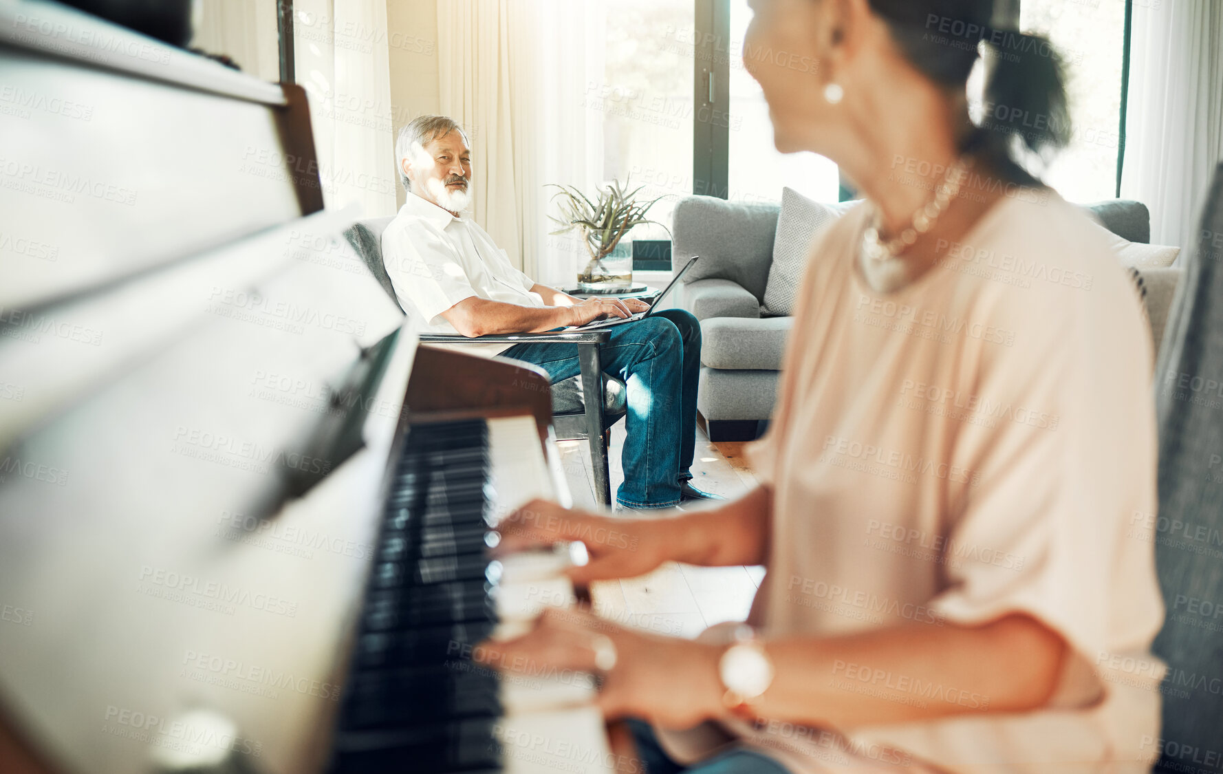 Buy stock photo Senior woman playing piano for music in living room for bonding, entertainment or having fun. Happy, smile and elderly Asian female person with husband in retirement enjoying keyboard at modern home.