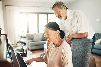 Buy stock photo Piano, music and a senior asian couple in their home together for love or romance in retirement. Smile, art or creative with a happy elderly man and woman playing an instrument in their house