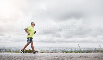 Buy stock photo Senior man, running and fitness on road for outdoor exercise, training or workout on mockup. Mature male person, athlete or runner in sports, health and wellness on mountain for hiking or trekking