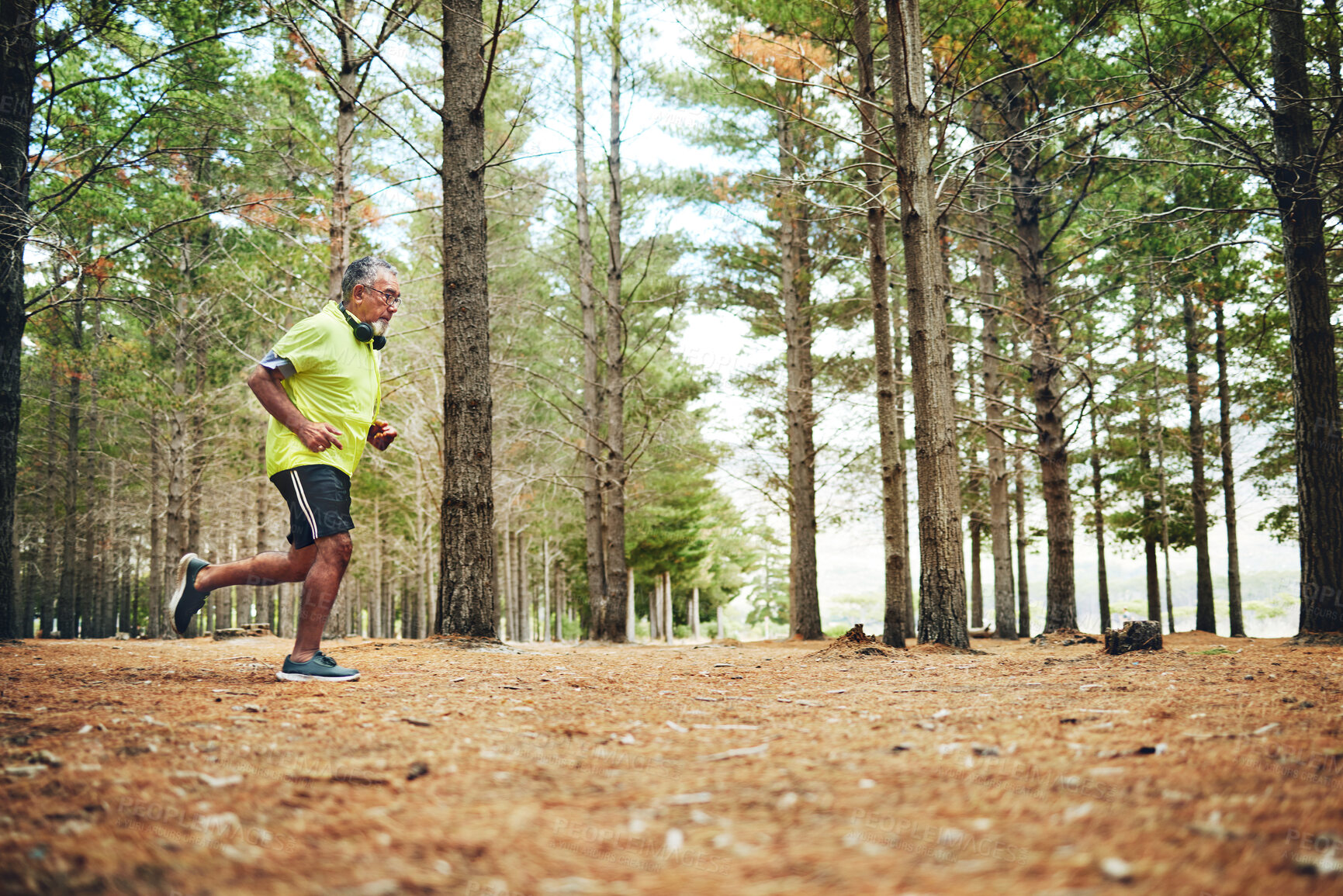 Buy stock photo Senior man, fitness and running in forest for workout, outdoor exercise or cardio training in nature. Mature and active male person, athlete or runner in woods with trees for trekking and hiking