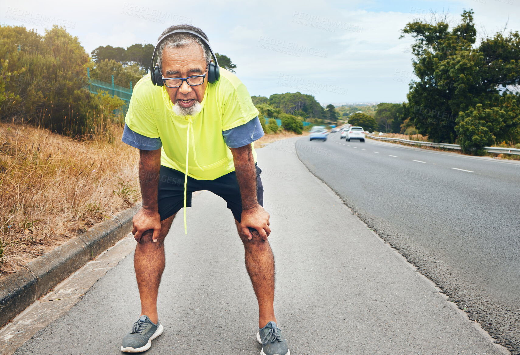 Buy stock photo Tired, road and senior man with fitness, fatigue and exercise with wellness, workout and training. Runner, athlete and old person with headset, outdoor and exhausted with burnout, breathing and relax