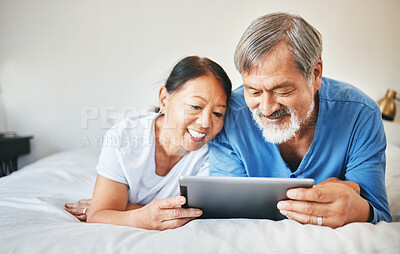 Buy stock photo Mature couple, tablet and relax in bed for love, online shopping and streaming multimedia. Happy asian man, woman and search digital blog in bedroom for social network, subscription and download app 