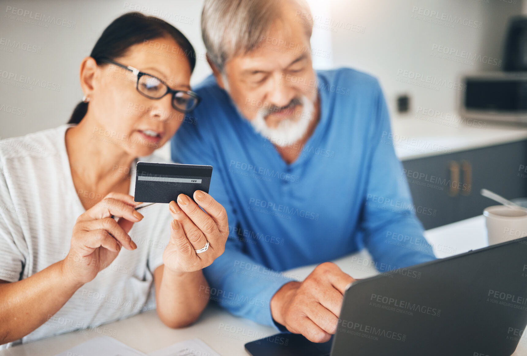 Buy stock photo Mature couple, credit card and laptop for home online shopping, loan application or financial management in kitchen. Man and woman with computer for internet banking, security numbers or registration