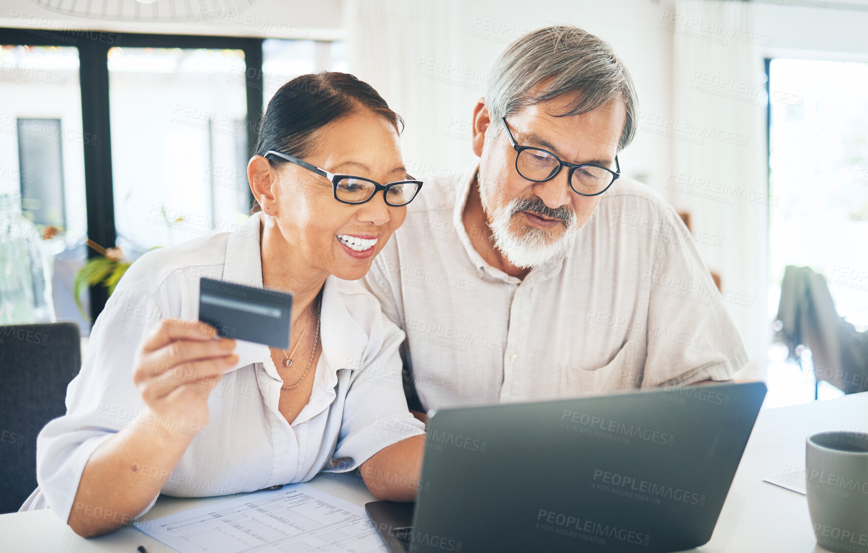 Buy stock photo Mature couple, credit card and computer for home online shopping, loan application or digital money or finance in kitchen. Happy woman and man on laptop internet banking, easy payment or registration