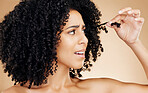 Hair care, afro and face of woman with problem, anxiety or worried about grooming mistake, beauty salon treatment or damage. Haircut disaster, broken dry strand and model stress on brown background