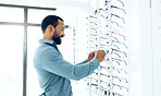 Optometry store glasses and man for decision, choice and eye care options for vision. Healthcare, ophthalmology and person in clinic to choose prescription lens, spectacles and frames for wellness