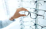 Optometry store, eyeglasses and hands of person shopping for lens frame decision, retail product or prescription eyewear. Eye care, optical eyesight accessory and closeup customer choice for glasses