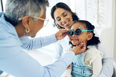 Buy stock photo Trial lens, optical and optometrist with child and mother at an eye care appointment for test. Health, wellness and senior optician with young mom and girl kid patient with tool in optometry clinic.