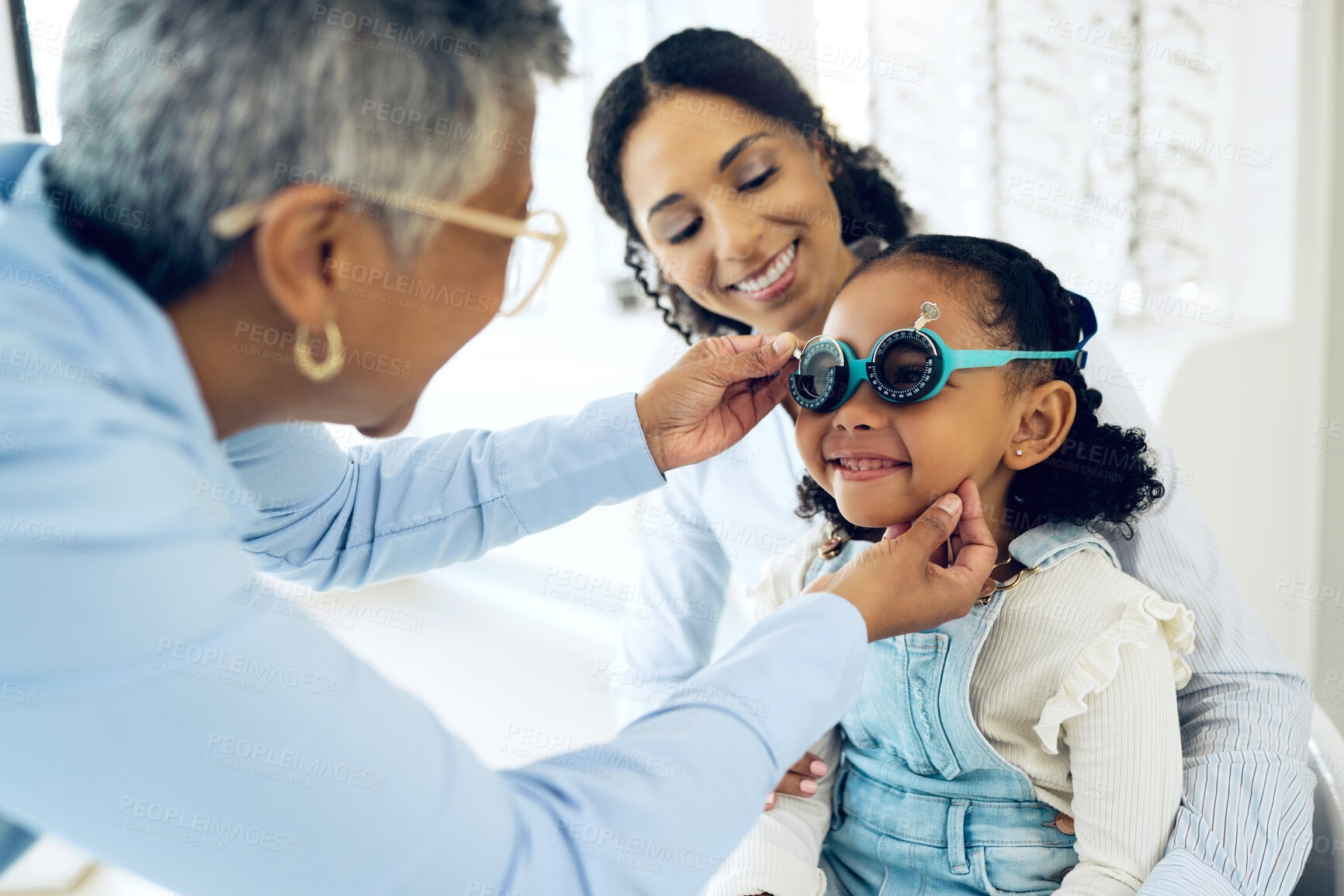 Buy stock photo Trial lens, optical and optometrist with child and mother at an eye care appointment for test. Health, wellness and senior optician with young mom and girl kid patient with tool in optometry clinic.