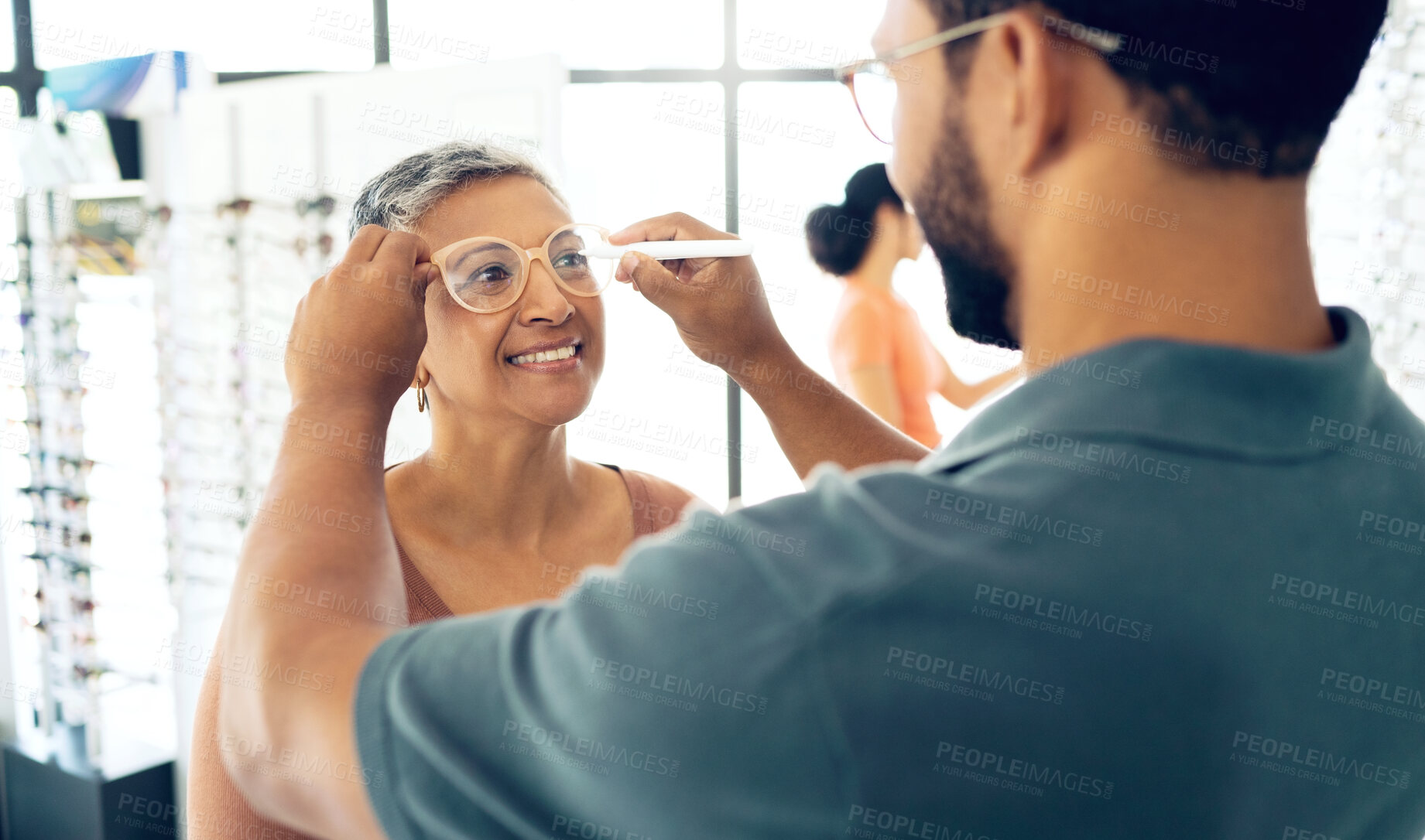 Buy stock photo Optometrist, test glasses and measure pupil distance of mature woman for prescription lens, check or exam in store. Smile, optician or man writing on spectacles for eye health, vision or consultation