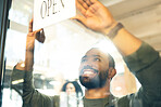 Happy man, small business and open sign on door or window in ready for service or welcome at cafe. Male person or waiter smile with entrance billboard at coffee shop, restaurant or cafeteria store