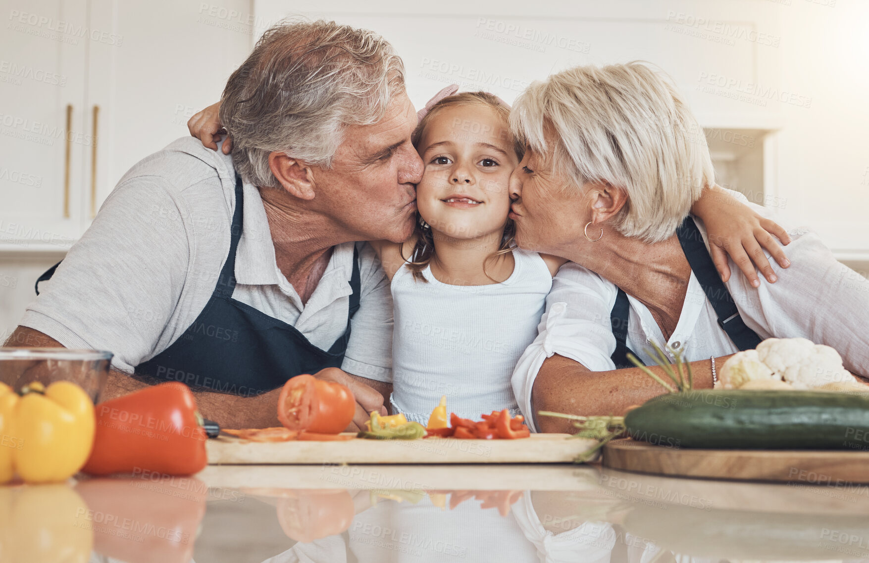 Buy stock photo Family, cooking and grandparents kiss girl child in kitchen with love, care and support at home. Food, learning and face of kid with elderly people together with vegetables, nutrition or prepare meal