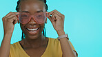 Portrait, funny and black woman with glasses, happiness and fantasy on a blue studio background. Face, African person and happy model with funky eyewear, trendy and silly with fashion and cheerful