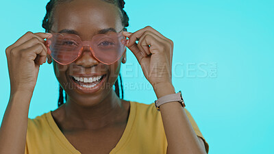 Buy stock photo Portrait, funny and woman with heart glasses, smile and fantasy with happiness on a blue background. Face, African person and happy model with funky eyewear, trendy and silly with fashion or cheerful
