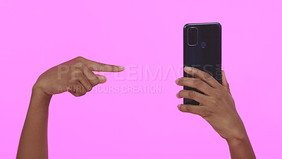 Buy stock photo Studio, hand holding phone and pointing for contact, connectivity or mobile networking. Social media, website and person with smartphone technology for communication, app or choice on pink background