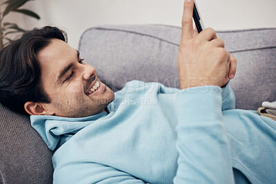 Buy stock photo Happy man, phone and relax on sofa for social media, communication or networking in living room at home. Male person smile and enjoying online chat on mobile smartphone app on lounge couch at house