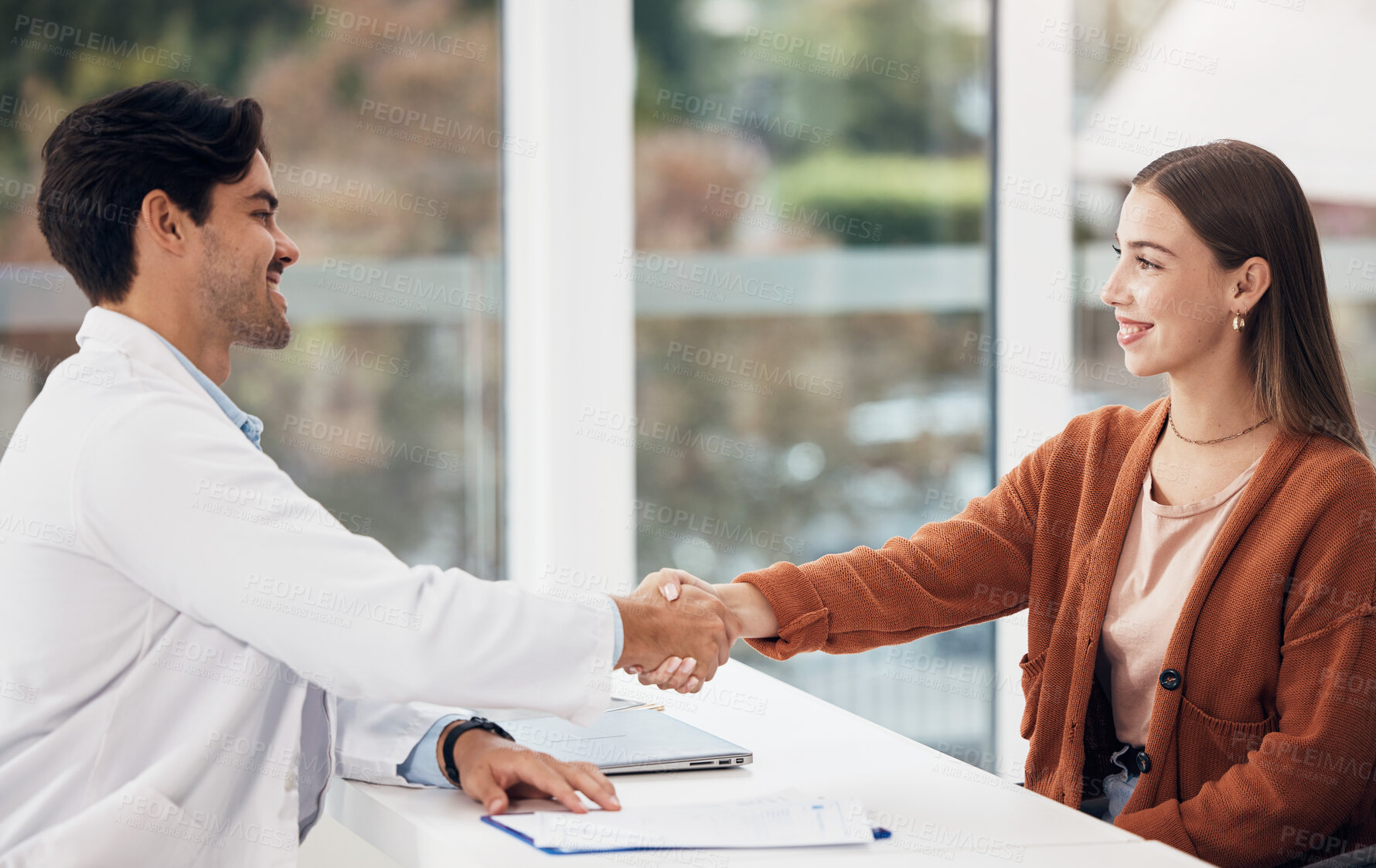 Buy stock photo Doctor, woman and handshake or welcome at hospital reception or help desk for healthcare support and thank you. Medical worker shaking hands with young patient for advice, help or clinic registration