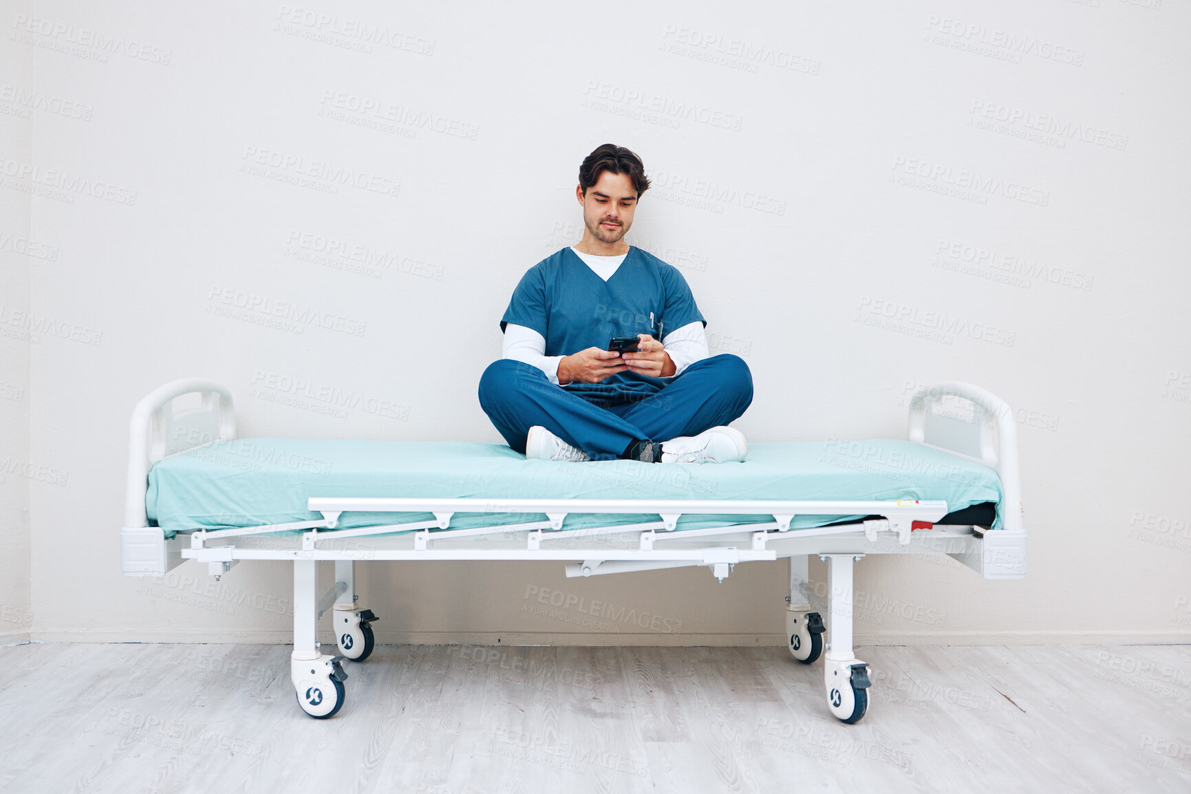 Buy stock photo Phone, nurse and man typing on bed in hospital, telehealth or relax on break on mockup space. Smartphone, stretcher and medical professional on internet, social media or communication on health app