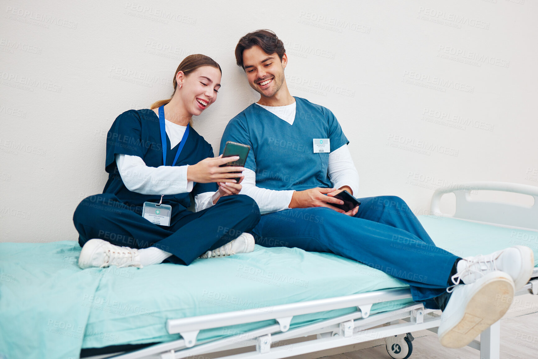 Buy stock photo Doctor, student phone and friends on break with laughing on a hospital, healthcare and clinic bed with social media. Smile, mobile and happy young people with rest from medical and nursing internship