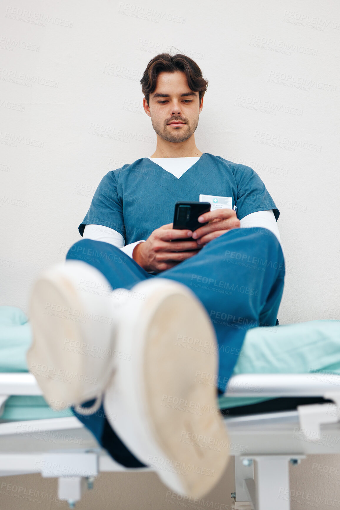 Buy stock photo Phone, nurse and man on bed to relax in hospital, typing email on break and telehealth. Smartphone, serious medical professional on internet and social media for communication on health app in clinic