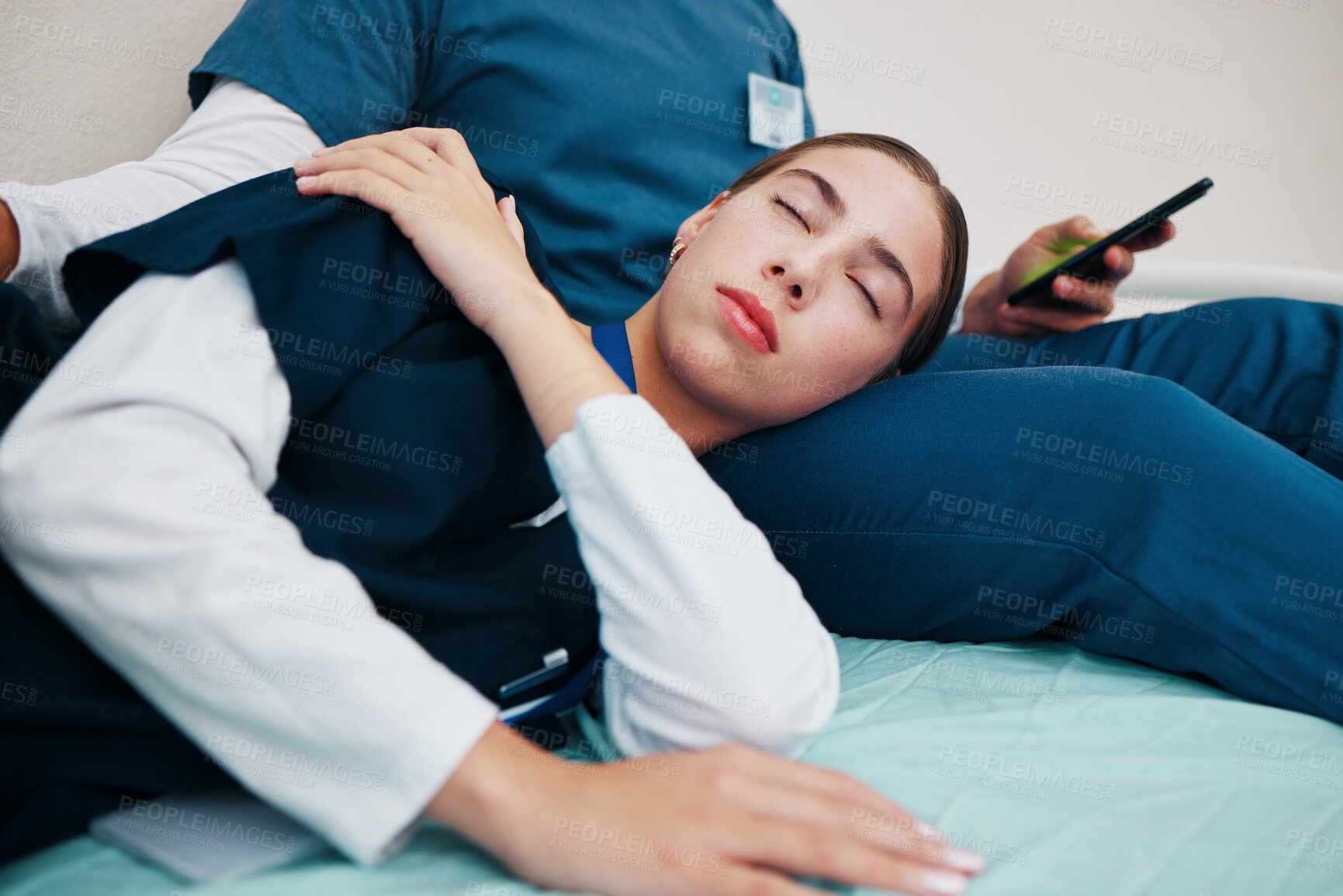 Buy stock photo Tired, sleeping and nurses relax on break in hospital bed in clinic with friends, fatigue and support. Healthcare, typing on phone and woman with medical staff for rest, nap and exhausted in clinic