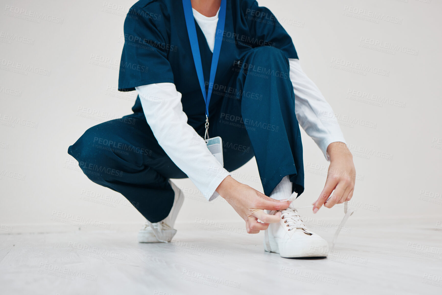 Buy stock photo Healthcare, shoes and tie with hands of a nurse in studio while getting ready for medical service closeup. Medical, lace and dressing with a medicine professional in uniform at a clinic for nursing