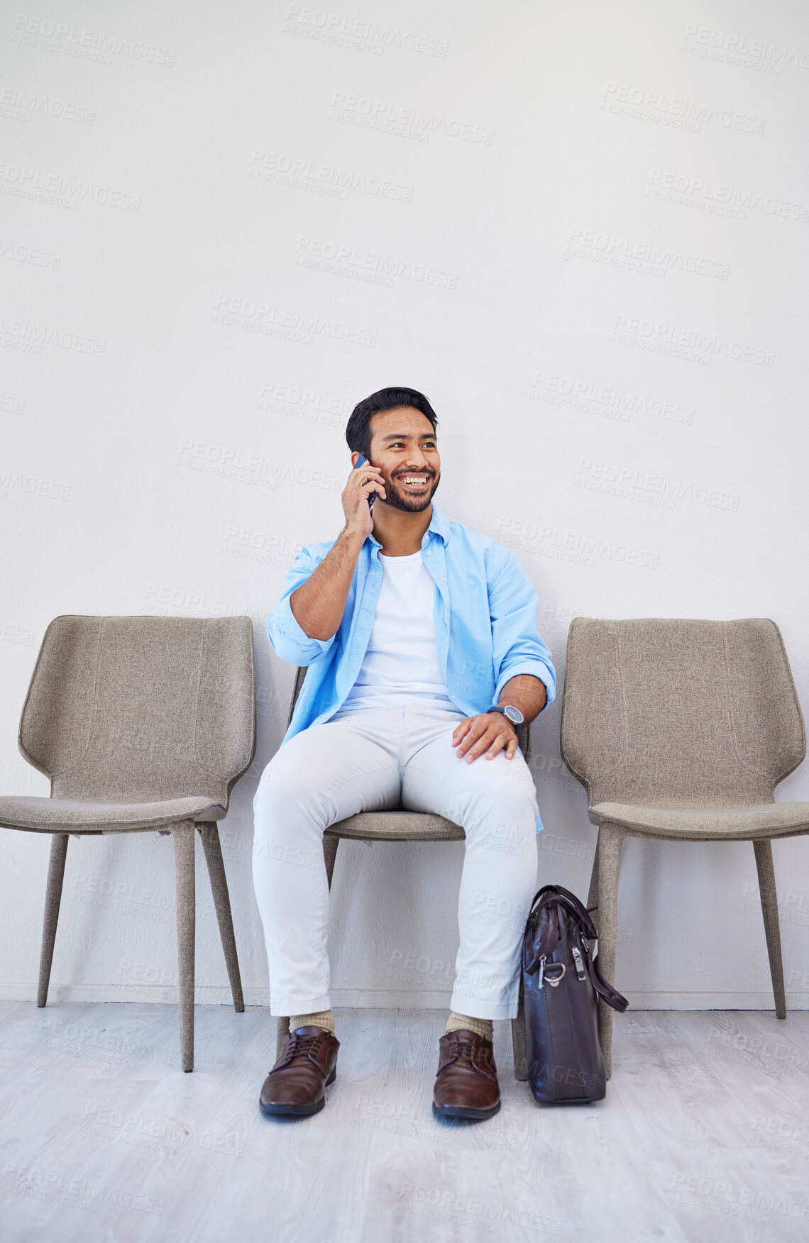 Buy stock photo Waiting room, phone call and man in an office for interview in job search for appointment. Hiring, career and Indian male person on mobile conversation for recruitment meeting with hr in workplace.