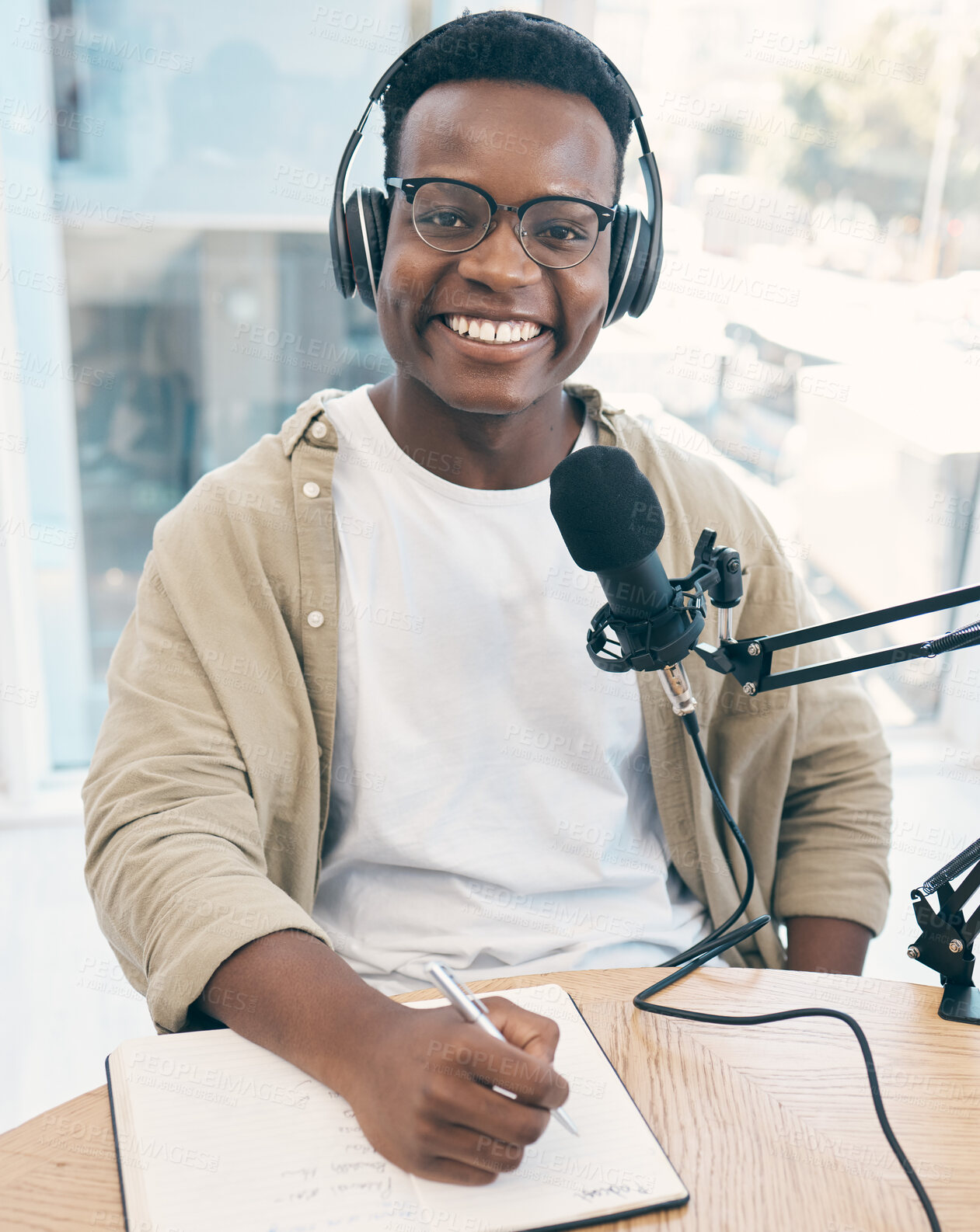 Buy stock photo Portrait, podcast and black man with a notebook, microphone and smile with news broadcasting. Face, African person and radio presenter with tech, share information and writing with content creator