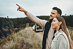 Couple, hiking and pointing on mountain for road trip, vacation or outdoor adventure together in nature. Happy man and woman smile for trekking, holiday vacation or travel on journey or showing path