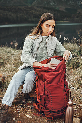 Buy stock photo Woman, hiking and packing backpack in nature with tablet, check and thinking by lake, mountain or outdoor. Girl, luggage and trekking with bad, technology and ideas on adventure in countryside