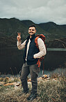 Happy man, portrait and peace sign on mountain for hiking, travel or outdoor backpacking in nature Male person or hiker smile with backpack for trekking, journey or adventure in happiness by the lake