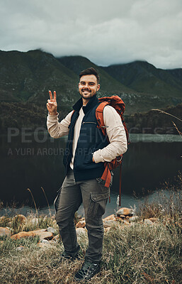 Buy stock photo Happy man, portrait and peace sign on mountain for hiking, travel or outdoor backpacking in nature Male person or hiker smile with backpack for trekking, journey or adventure in happiness by the lake
