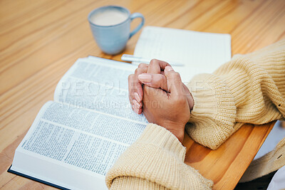 Hands, bible and praying at table, religion and Christian worship in home at desk. Closeup, holy book and woman in meditation for God, Jesus and Christ for faith in spiritual gospel, praise or hope