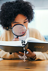 Bible, magnifying glass and woman with investigation, religion research and Christian study. Book, learning and information search in home with cross, story analysis and lens for spiritual knowledge