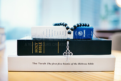 Books, stack and closeup on table for faith, Abrahamic religion or rosary with crucifix for study in home. Knowledge, holy spirit and education with cross for Jesus, Muhammad or Moses with solidarity