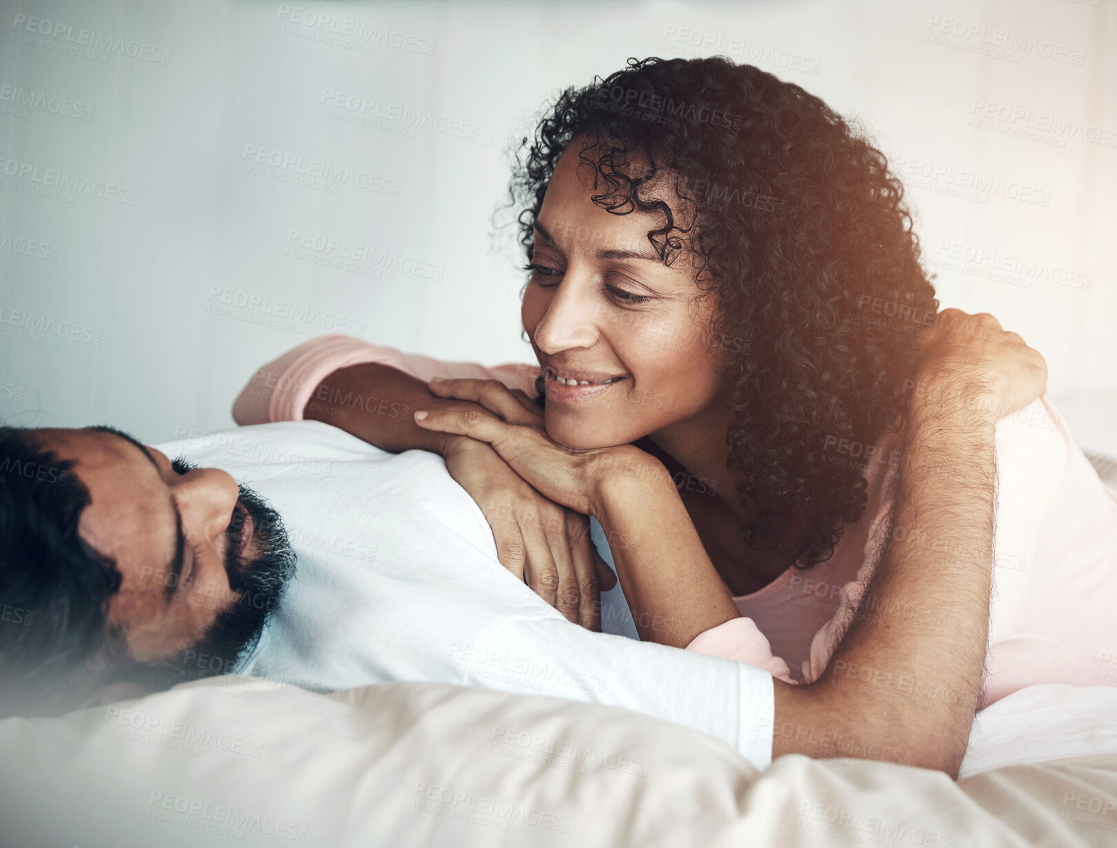 Buy stock photo Bed, couple and smile and laying together in bedroom, love and bonding in marriage. Happy man and woman, calm and relaxing at home, trust and conversation in morning, peace on vacation or holiday