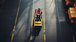 Top-down view: Worker with forklift ready to move boxes in distribution center.