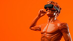 Sculpture or statue of David wearing a VR headset on an orange background