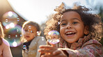 Group of diverse kids with bubbles. Exciting outdoor weekend fun activity