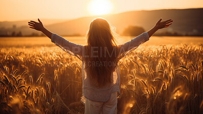 Happy and joyful woman raising arms in a rural field. Woman praising or worship in sunset