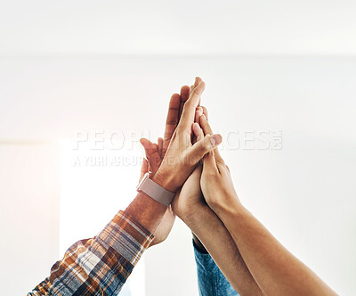 Buy stock photo Shot of a group of colleagues giving each other a high five in a modern office