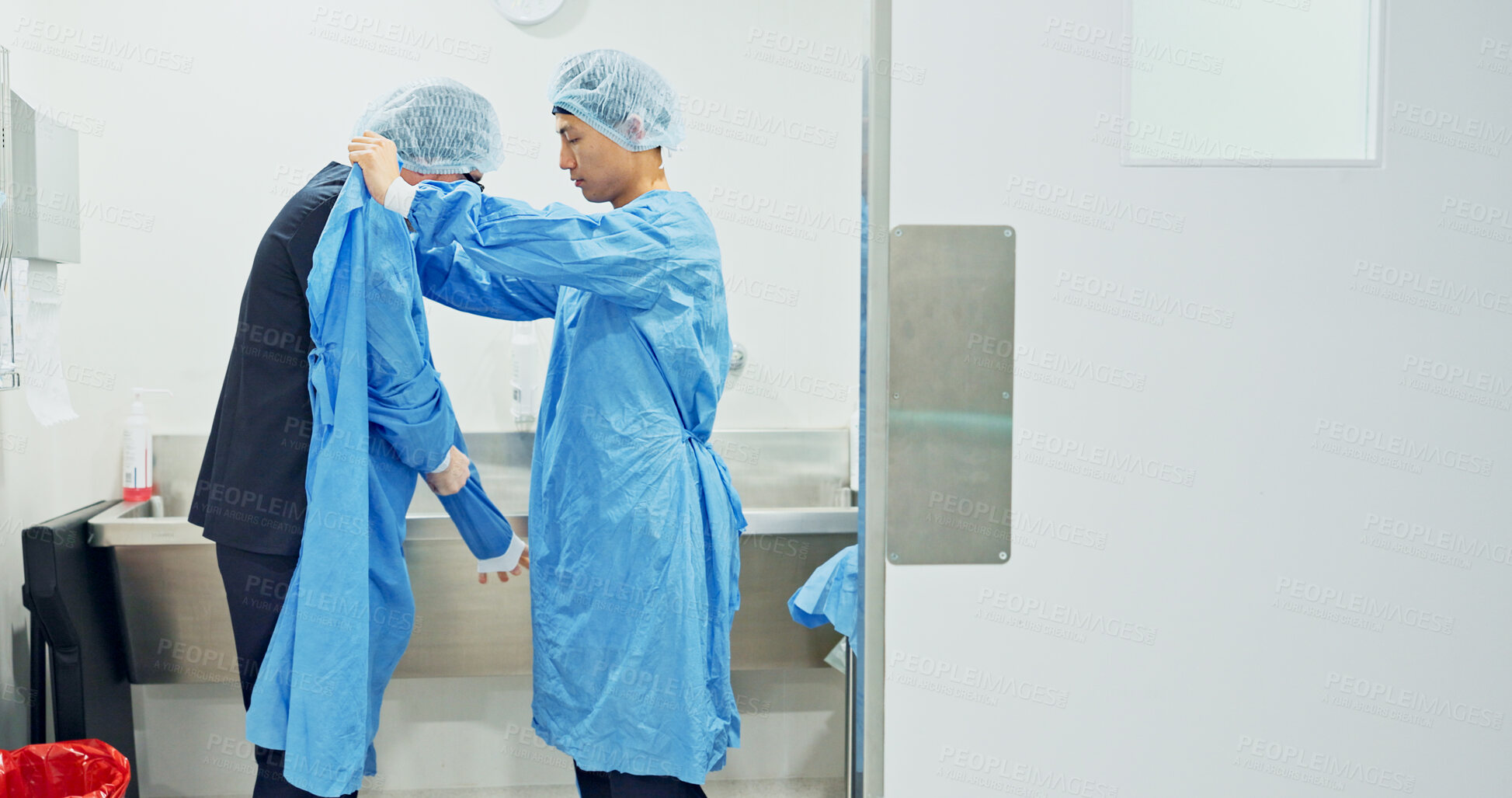 Buy stock photo Team, doctors and washing hands, put on theatre gown or prepare to start surgery or operation in hospital. Surgeon cleaning with water, medical healthcare or nurse help man wipe for hygiene or safety