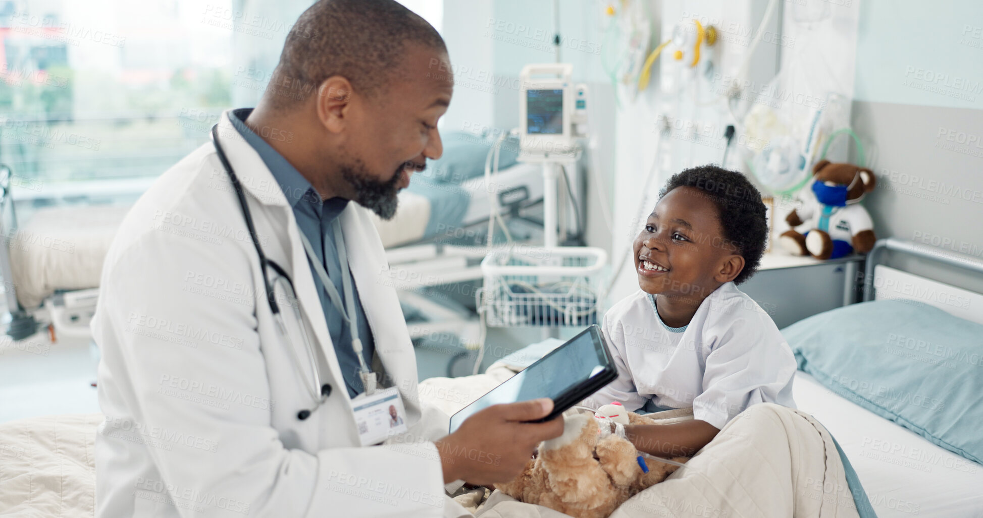 Buy stock photo Doctor, African boy child and hospital with tablet, smile or rest for recovery from surgery, consulting or inspection. Kid, happy and medic for check, touchscreen or talk in clinic for rehabilitation