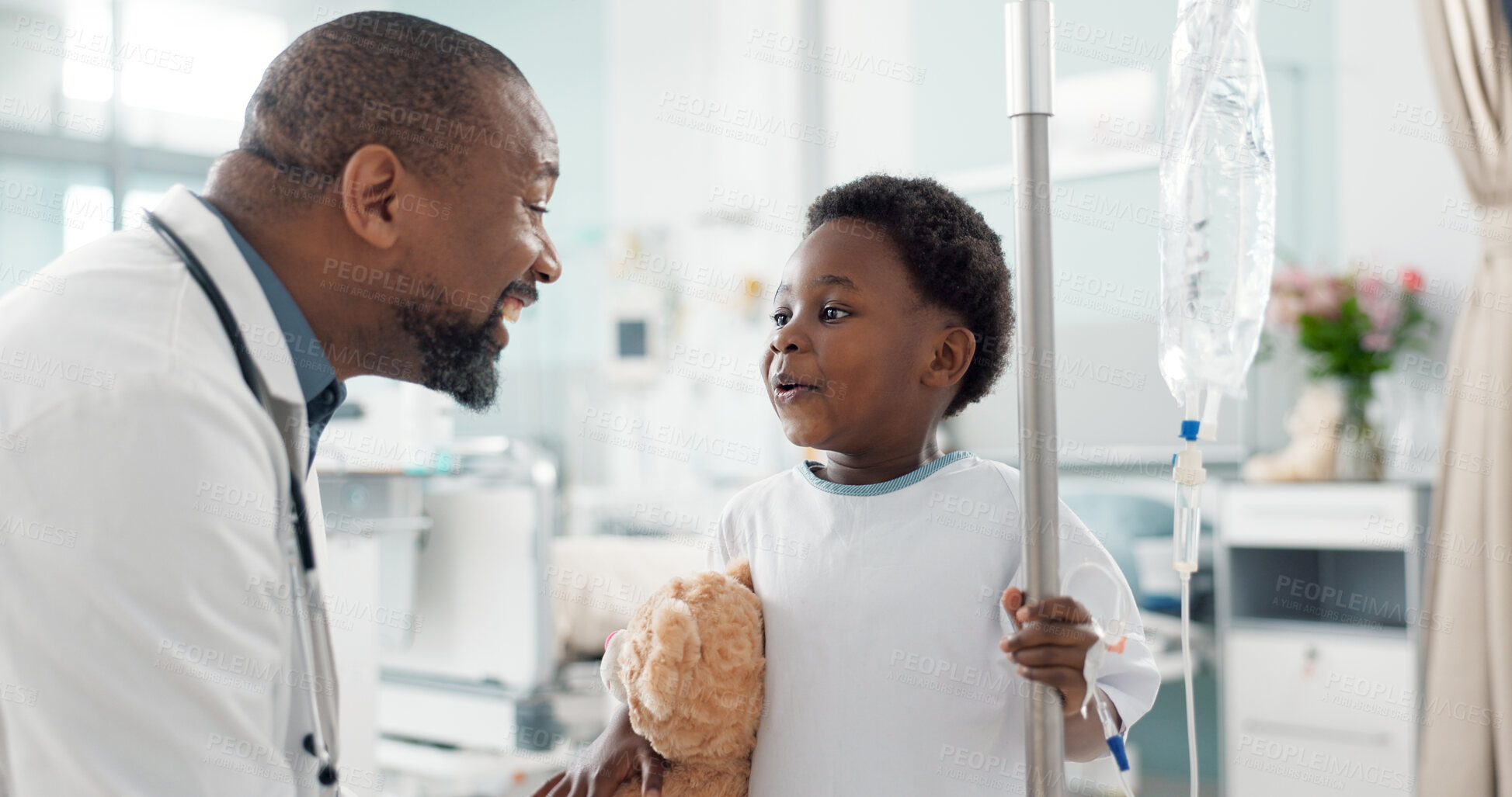 Buy stock photo Pediatrician, happy and doctor playing with child as care, support and kindness in healthcare in a hospital or clinic. Iv drip, teddy bear and African professional with medical compassion for kid
