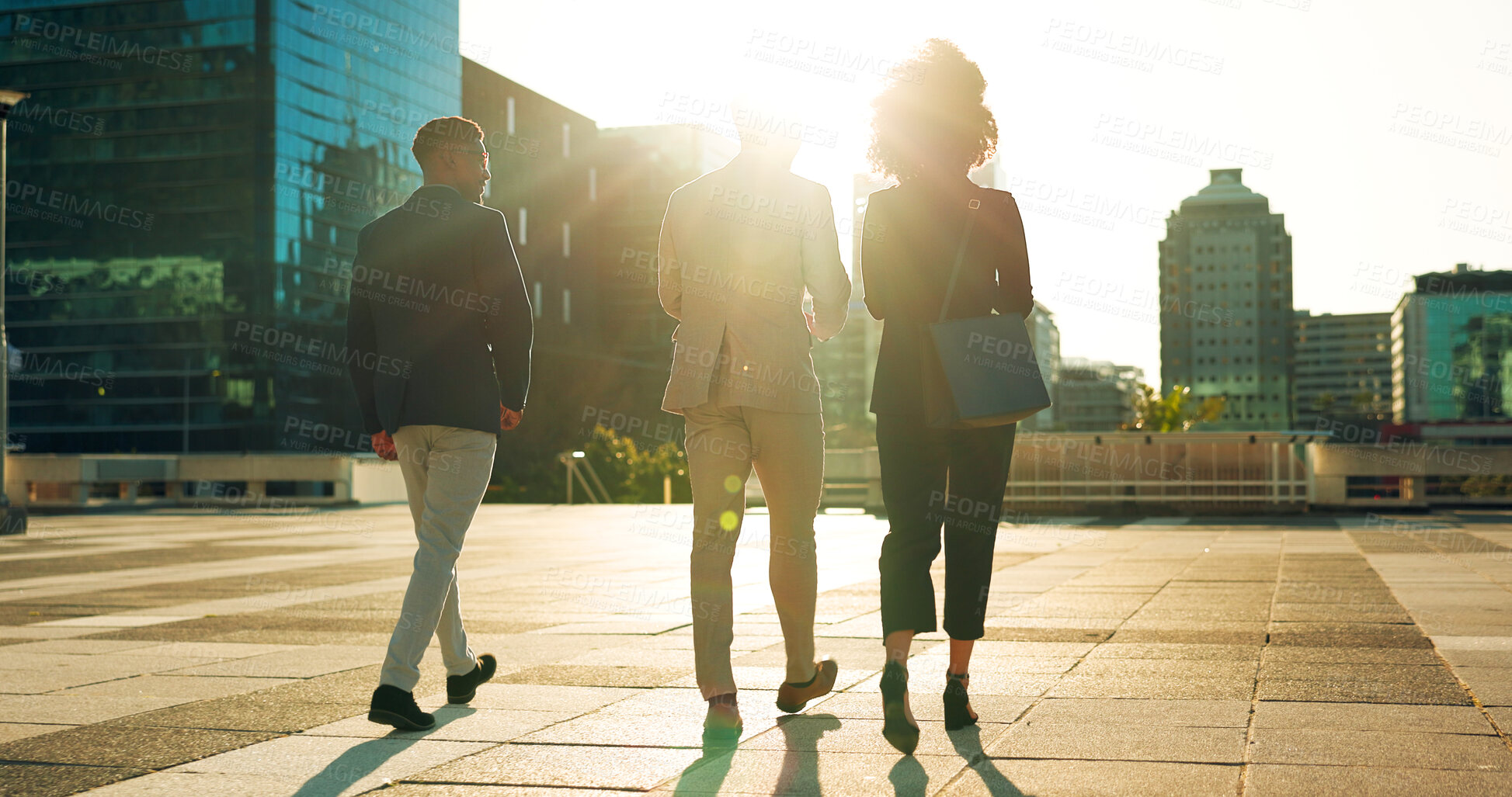 Buy stock photo Back, business team and walking outdoor in city for morning travel to work, conversation and lens flare. Rear View, professional workers and moving in urban town with communication and networking